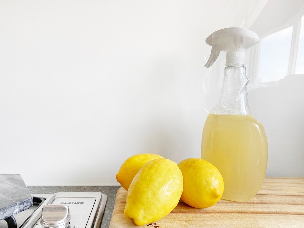 schoonmaken fles met drie citroenen op een aanrecht